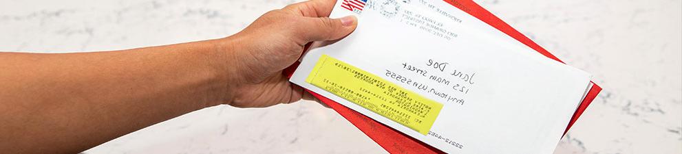 Person holding stack of forwarded USPS mail.